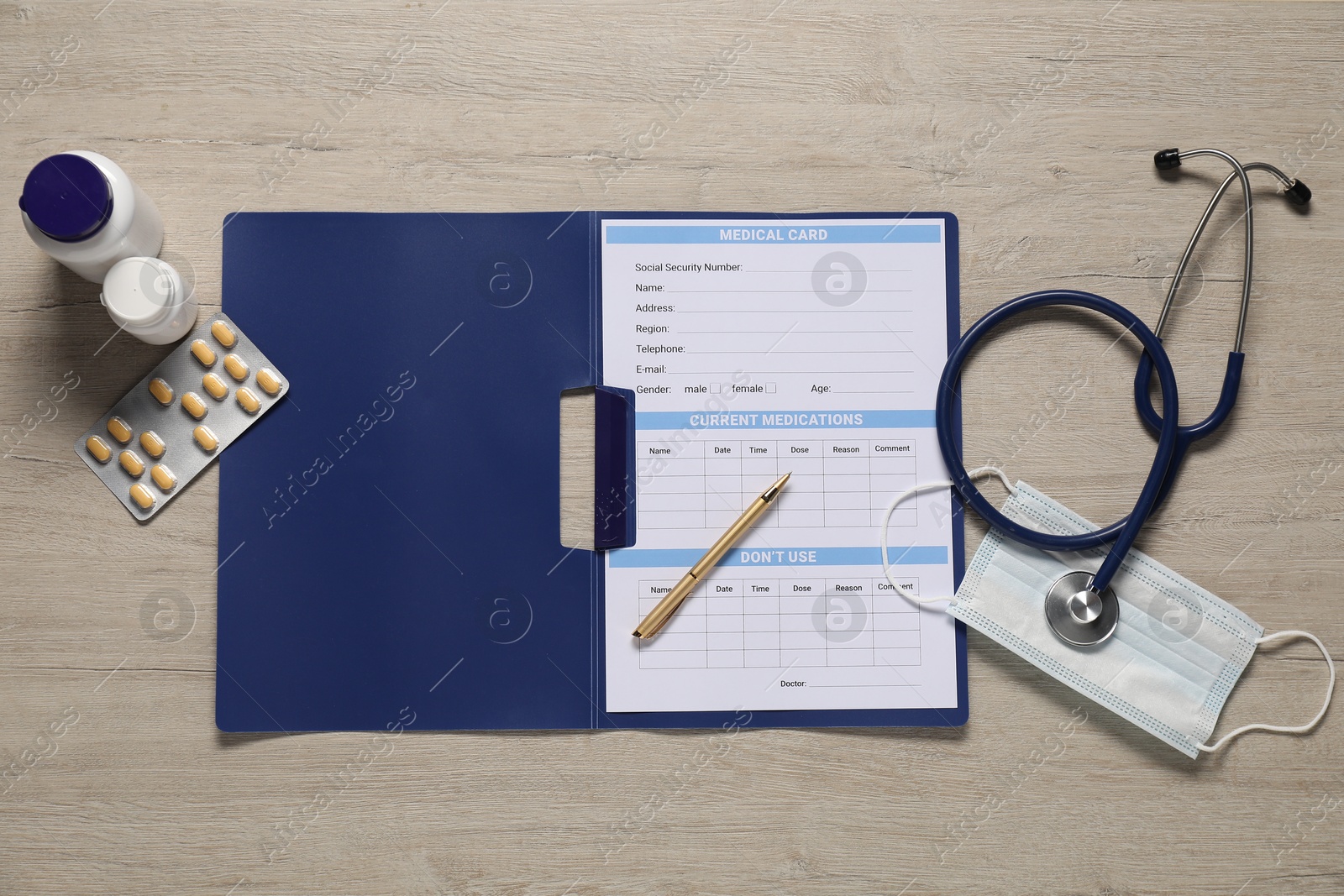 Photo of Flat lay composition with medical card form on light wooden background