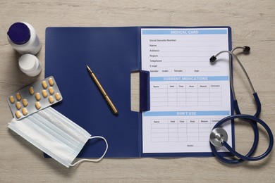 Flat lay composition with medical card form on light wooden background