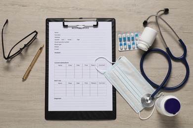 Flat lay composition with medical card form on light wooden background