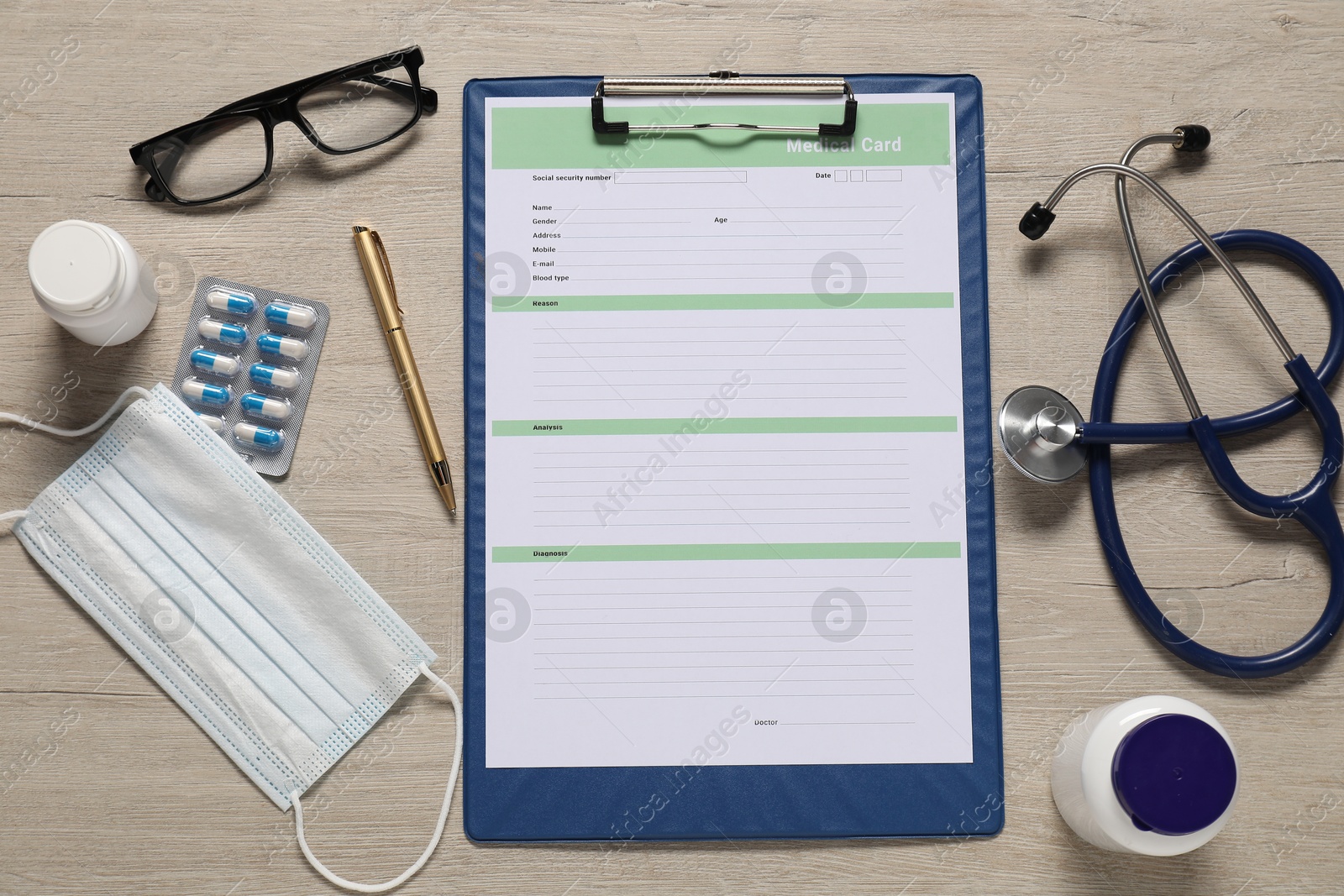 Photo of Flat lay composition with medical card form on light wooden background