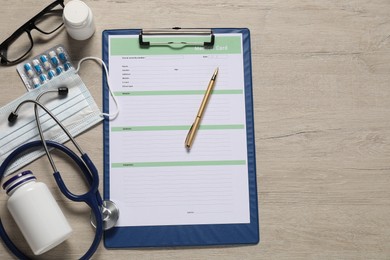 Photo of Flat lay composition with medical card form on light wooden background