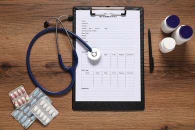 Flat lay composition with medical card form on wooden background