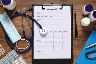 Photo of Flat lay composition with medical card form on wooden background