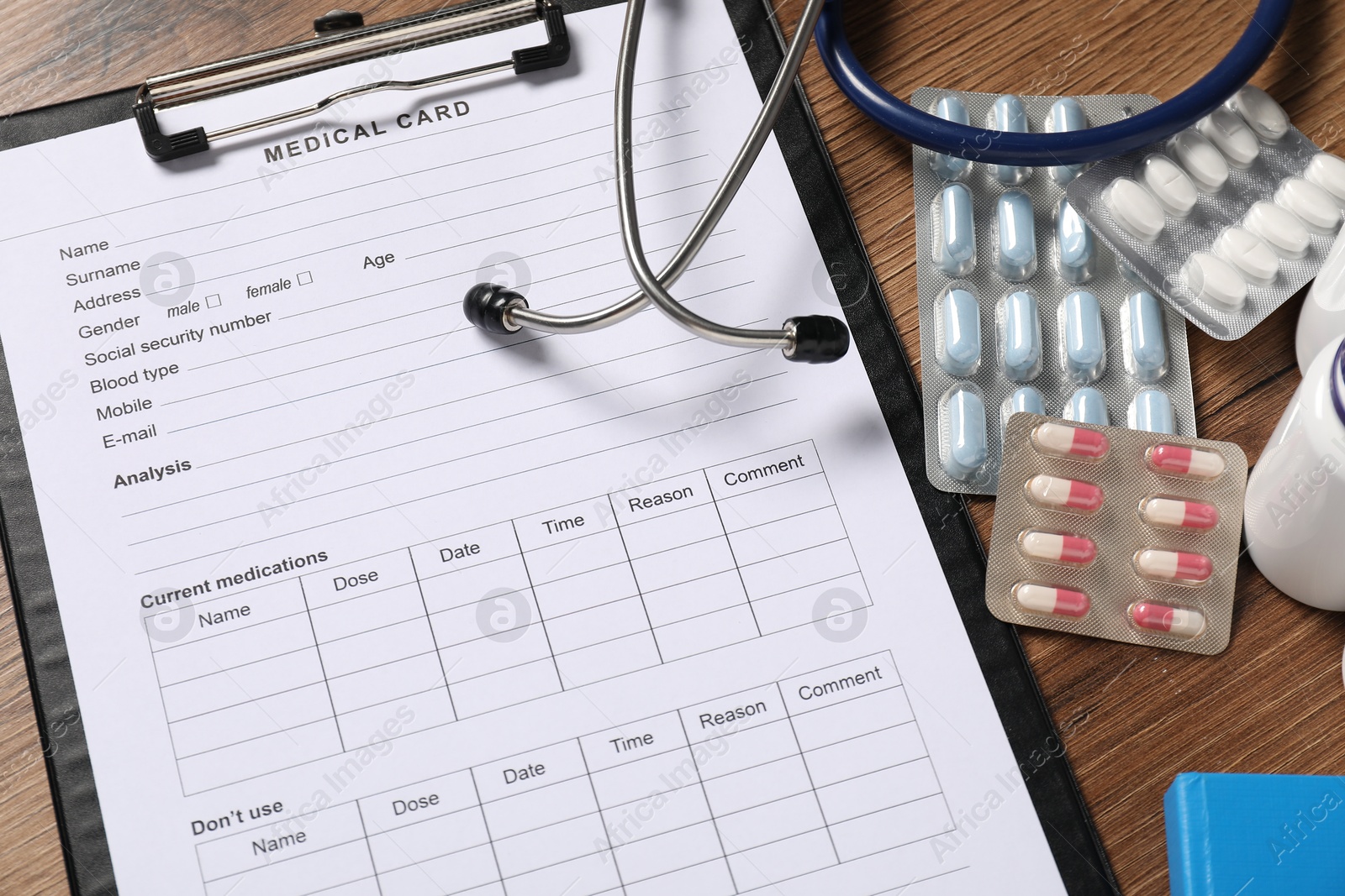 Photo of Composition with medical card form on wooden background, closeup