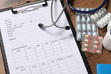 Composition with medical card form on wooden background, closeup