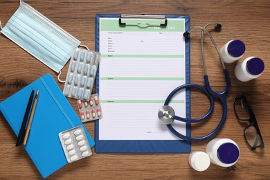 Photo of Flat lay composition with medical card form on wooden background