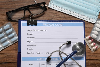 Flat lay composition with medical card form on wooden background