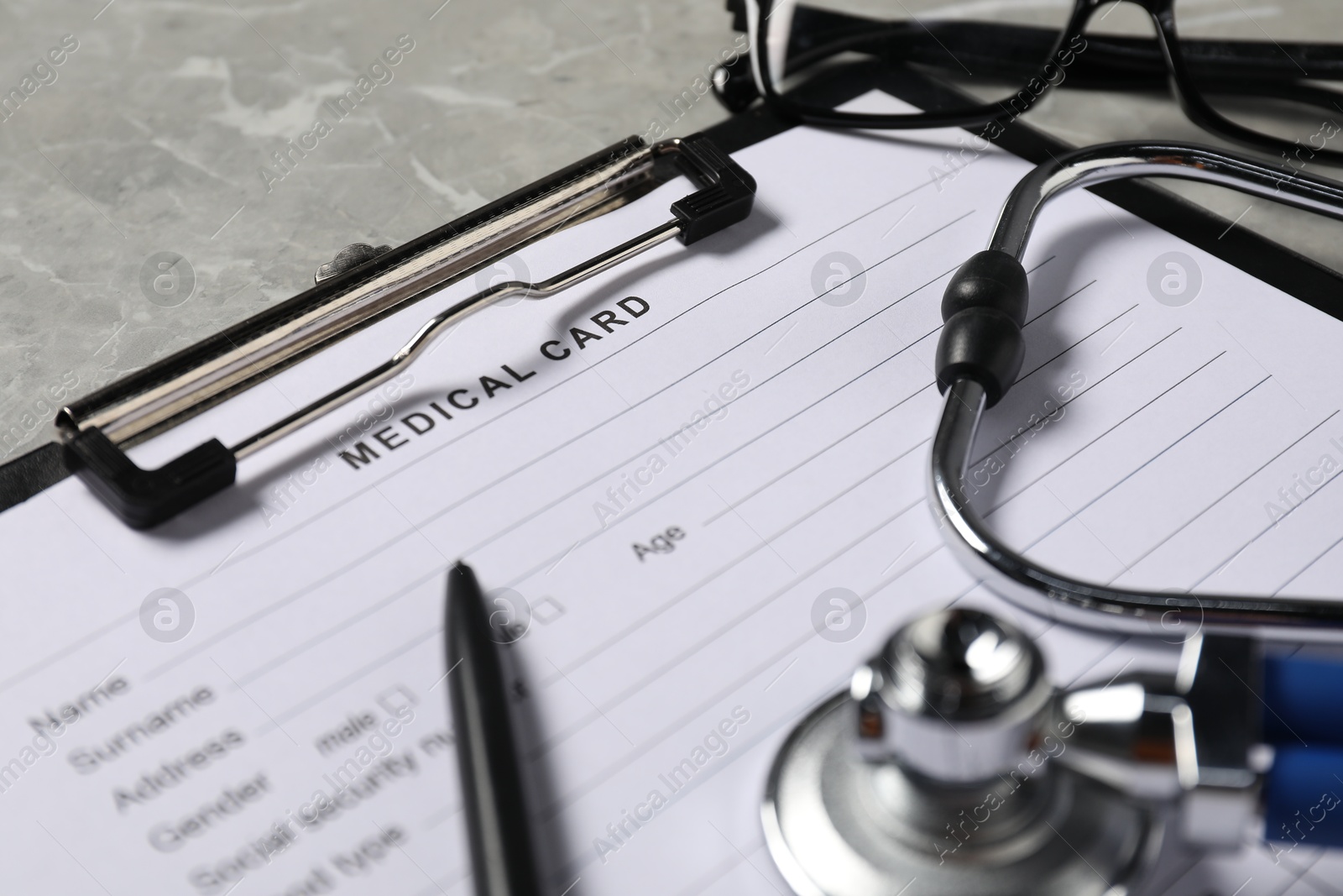 Photo of Medical card form and pen on grey background, closeup