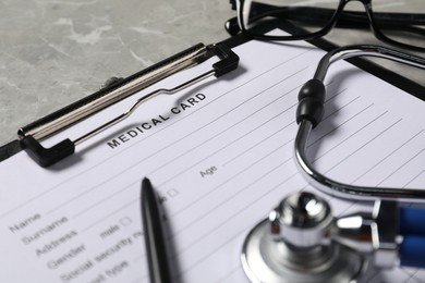 Medical card form and pen on grey background, closeup