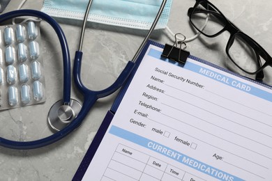 Photo of Composition with medical card form on grey background, closeup