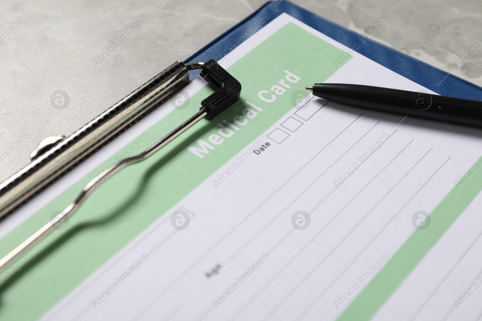 Photo of Medical card form and pen on grey background, closeup