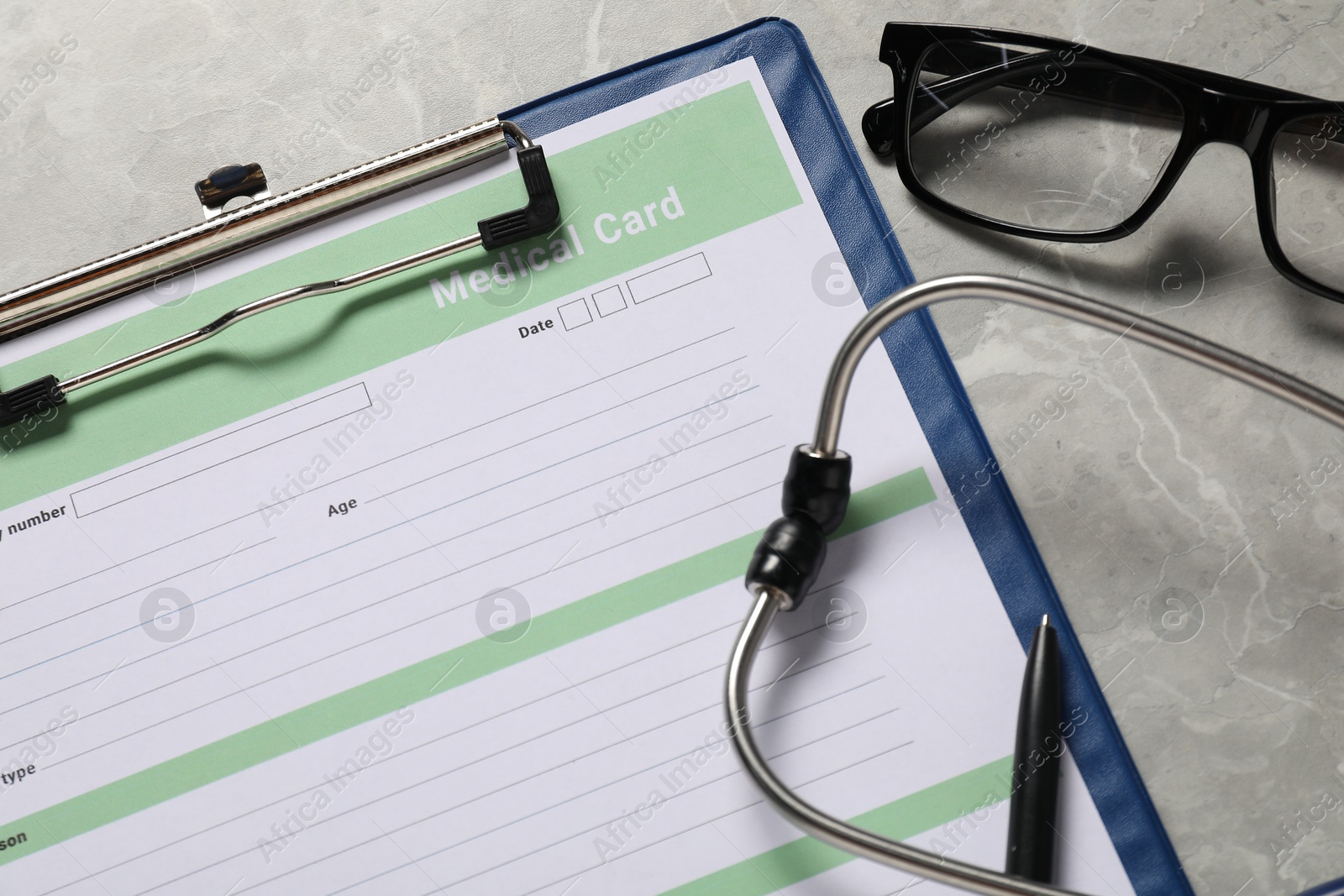 Photo of Composition with medical card form on grey background, closeup