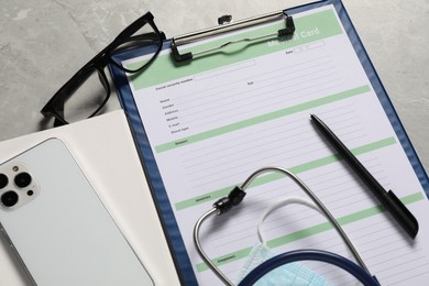 Photo of Composition with medical card form and pen on grey background, closeup