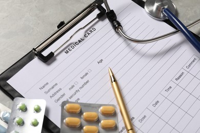 Photo of Composition with medical card form and pen on grey background, closeup