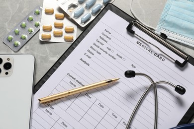 Photo of Composition with medical card form and pen on grey background, closeup