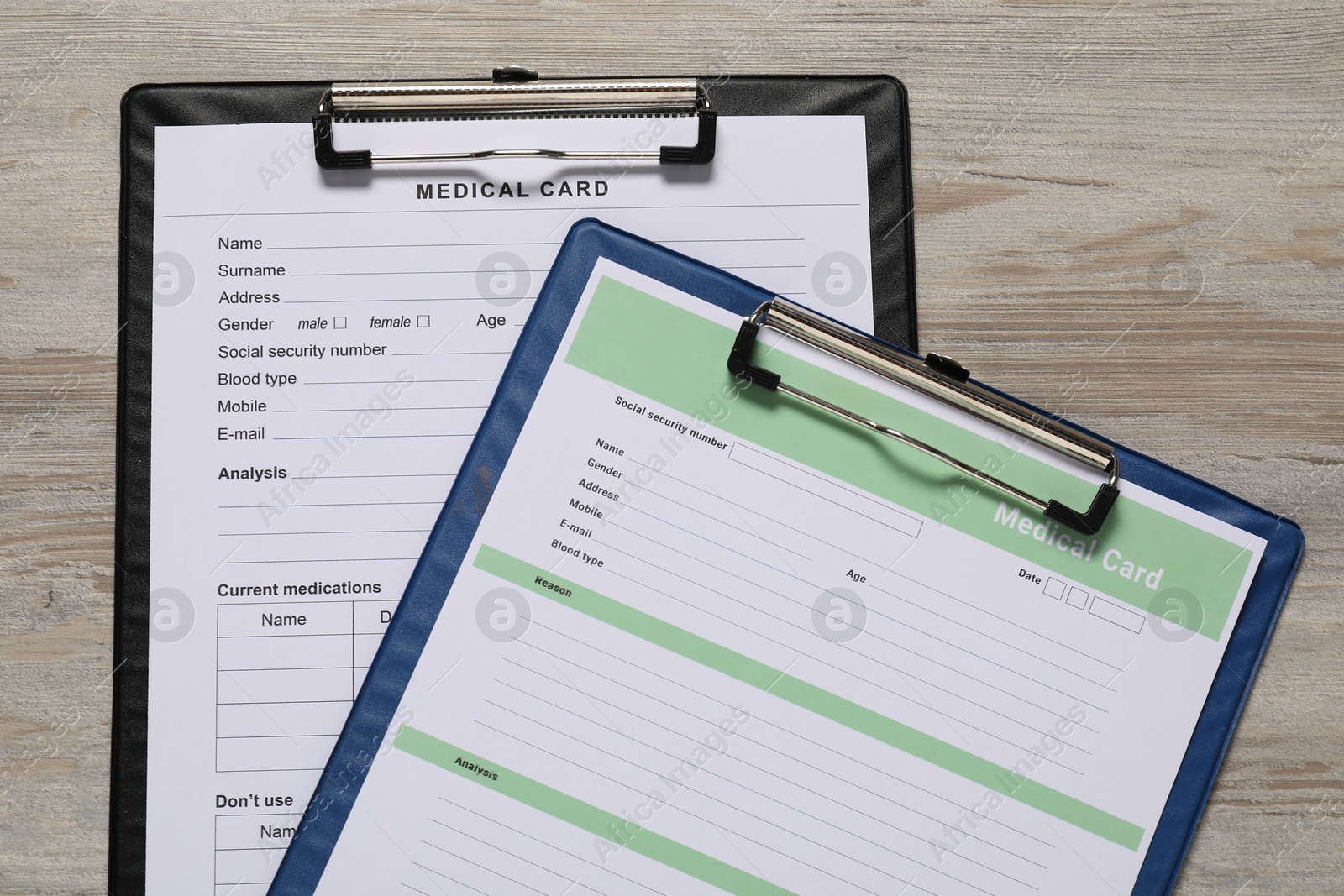 Photo of Medical card forms on light wooden background, top view