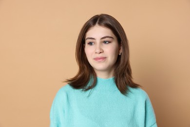 Photo of Portrait of beautiful teenage girl on beige background