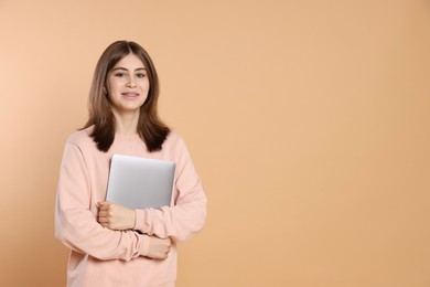 Photo of Portrait of teenage girl with laptop on beige background. Space for text