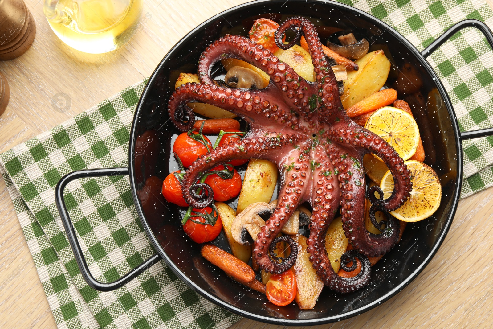 Fried octopus with mushrooms, lemon and vegetables in pan on wooden table, top view Photo of Fried octopus with mushrooms, lemon and vegetables in pan on wooden table, top view