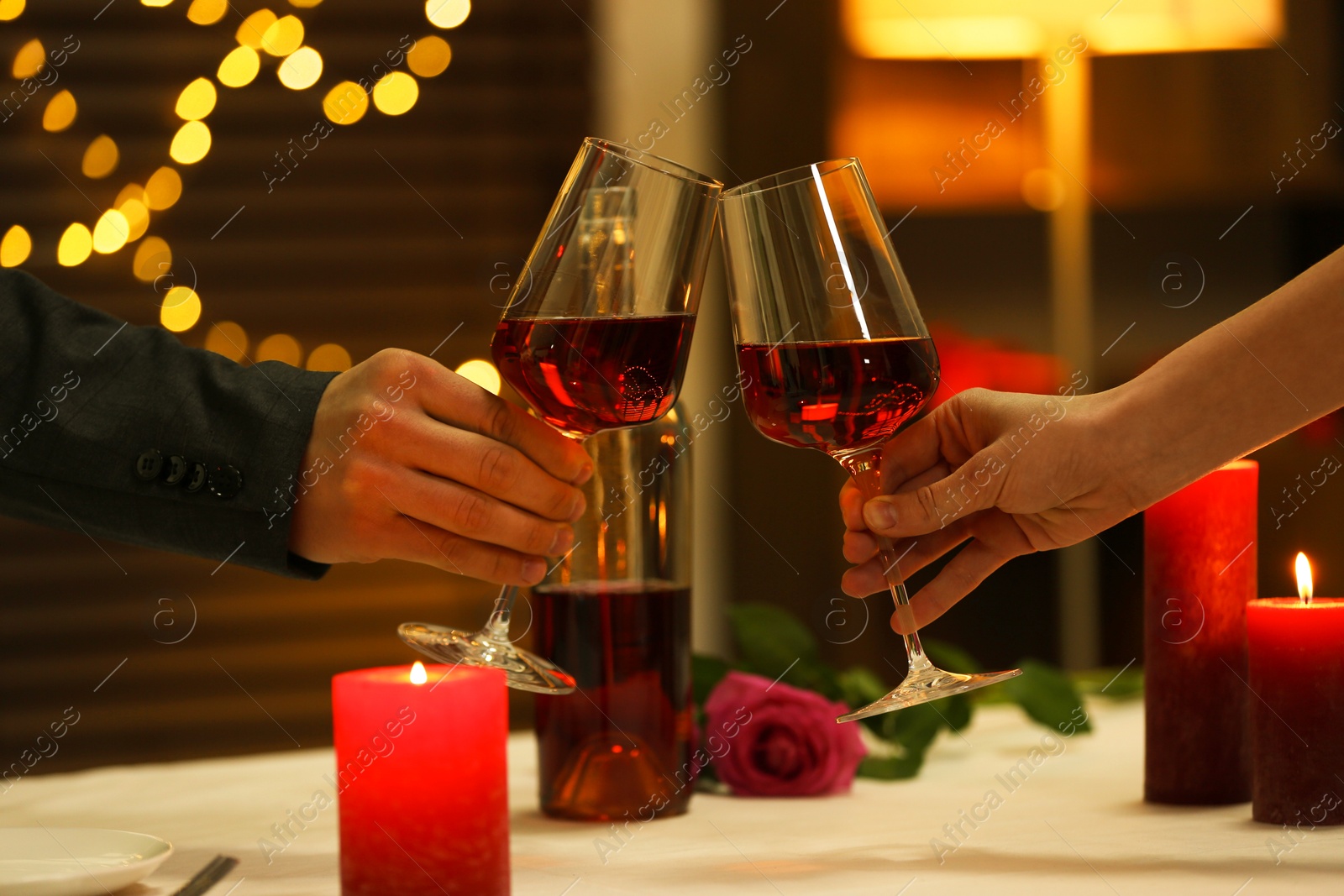 Photo of Couple clinking glasses of wine in restaurant, closeup. Romantic dinner