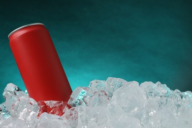 Photo of Refreshing drink in can on ice cubes against teal background, closeup
