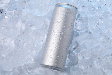 Photo of Refreshing drink in can on ice cubes, top view