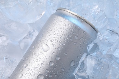 Photo of Refreshing drink in can on ice cubes, closeup