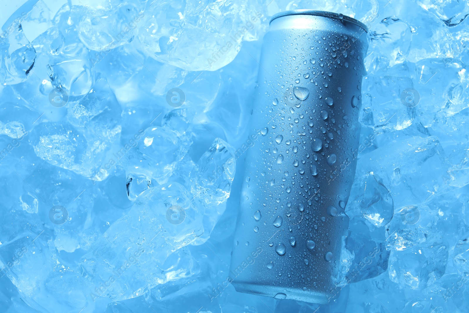 Refreshing drink in can on ice cubes, top view. Toned in blue Photo of Refreshing drink in can on ice cubes, top view. Toned in blue