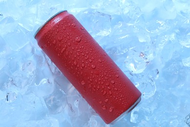 Photo of Refreshing drink in can on ice cubes, top view