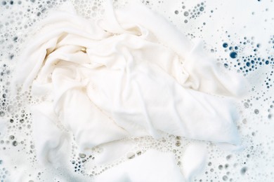 Photo of White clothes soaked in water before washing, top view