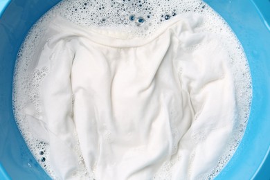 Photo of White clothes soaked in water before washing, top view