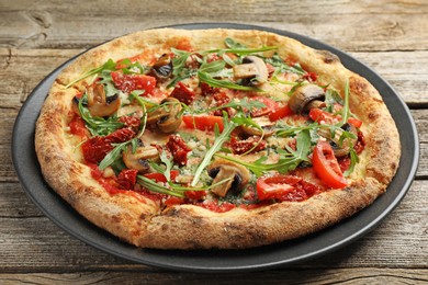 Photo of Tasty pizza with mushrooms, tomatoes and arugula on wooden table, closeup