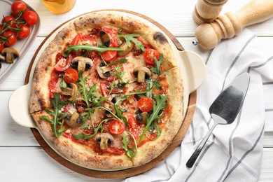 Tasty pizza with mushrooms, tomatoes, arugula and server on white wooden table, flat lay