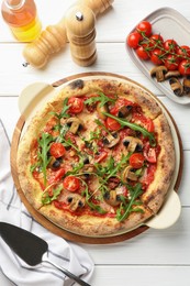 Tasty pizza with mushrooms, tomatoes, arugula and server on white wooden table, flat lay