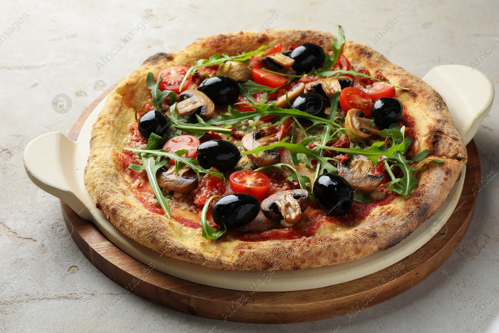 Photo of Tasty pizza with mushrooms, black olives and arugula on light grey table, closeup