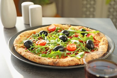 Photo of Delicious pizza with olives, cherry tomatoes and arugula on grey table indoors, closeup