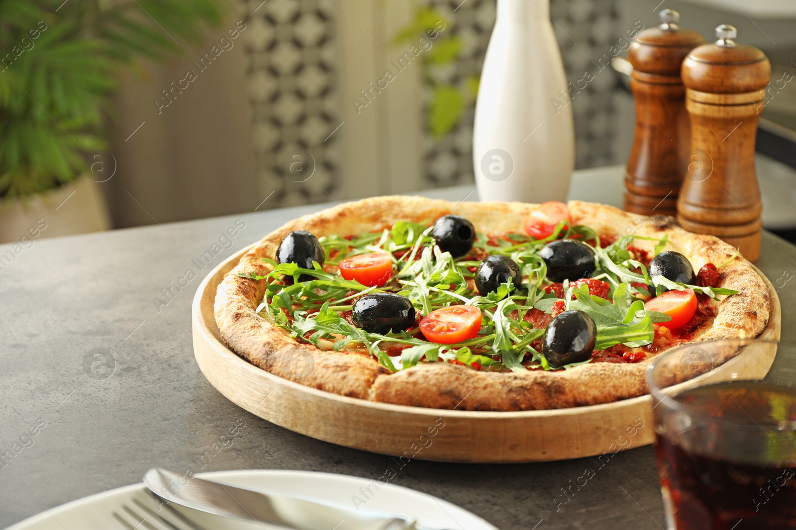 Photo of Delicious pizza with olives, cherry tomatoes, arugula and soda drink on grey table indoors, closeup. Space for text