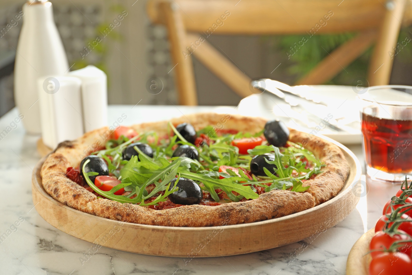 Photo of Delicious pizza with olives, cherry tomatoes, arugula and soda drink on white marble table indoors, closeup