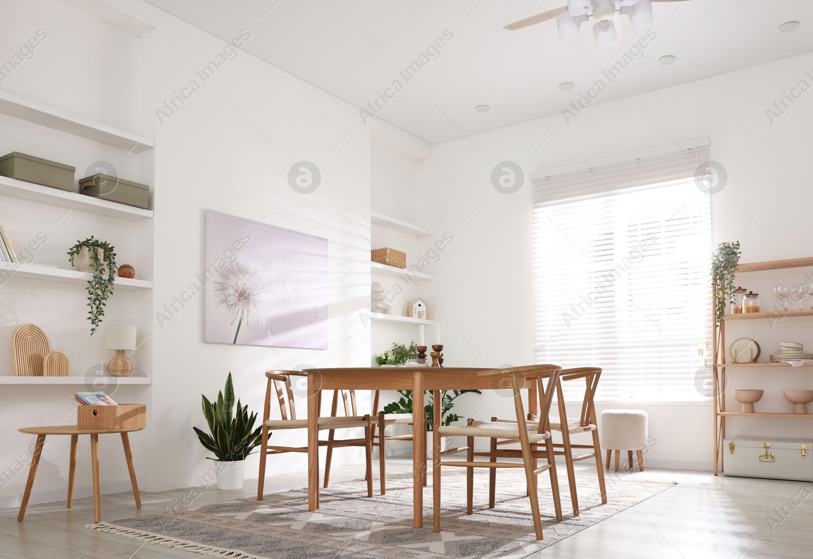 Photo of Stylish room with wooden table, chairs and houseplants. Interior design