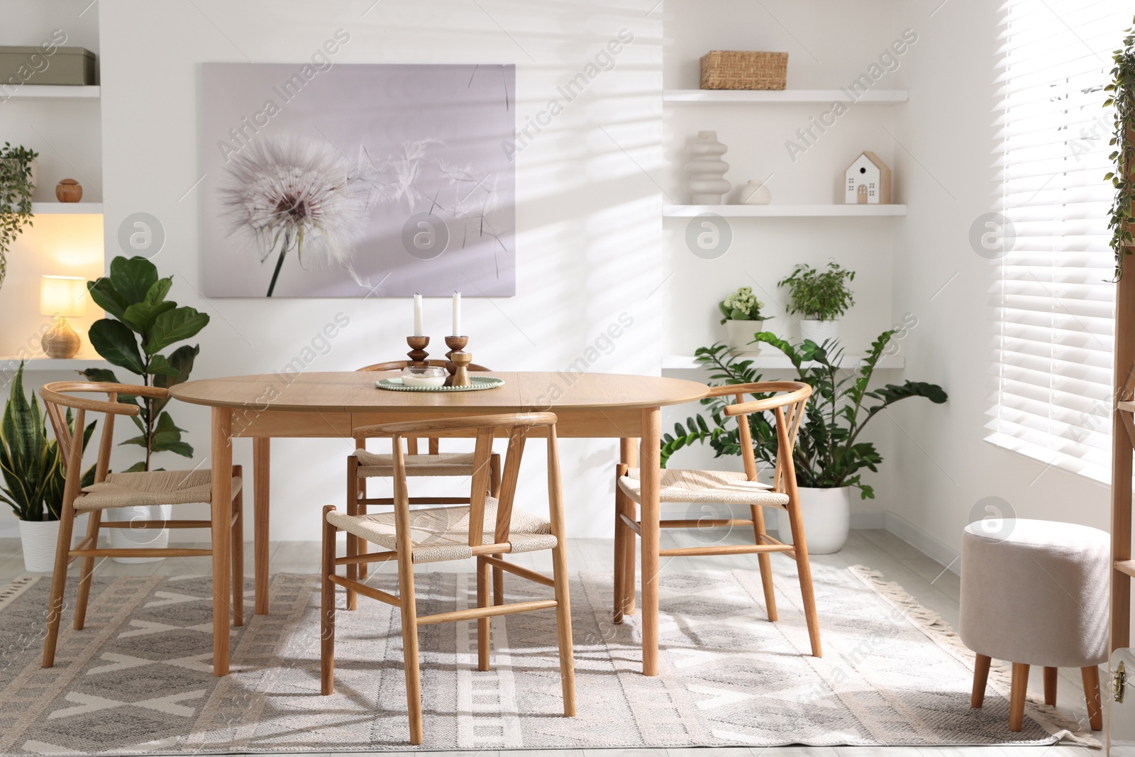 Photo of Stylish room with wooden table, chairs and houseplants. Interior design