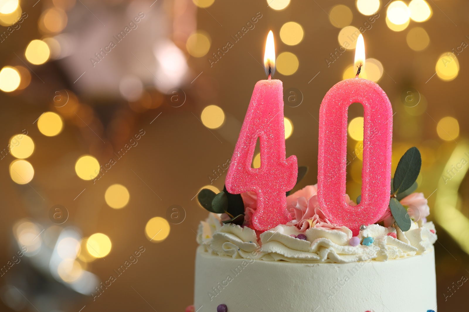 Photo of 40th birthday. Tasty cake with burning number shaped candles and sprinkles on blurred background with lights, space for text. Bokeh effect