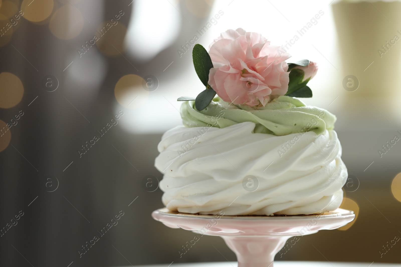 Photo of Tasty cupcake with floral decor on blurred background with lights, space for text. Bokeh effect