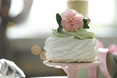 Photo of Tasty cupcake with floral decor on blurred background with lights, space for text. Bokeh effect