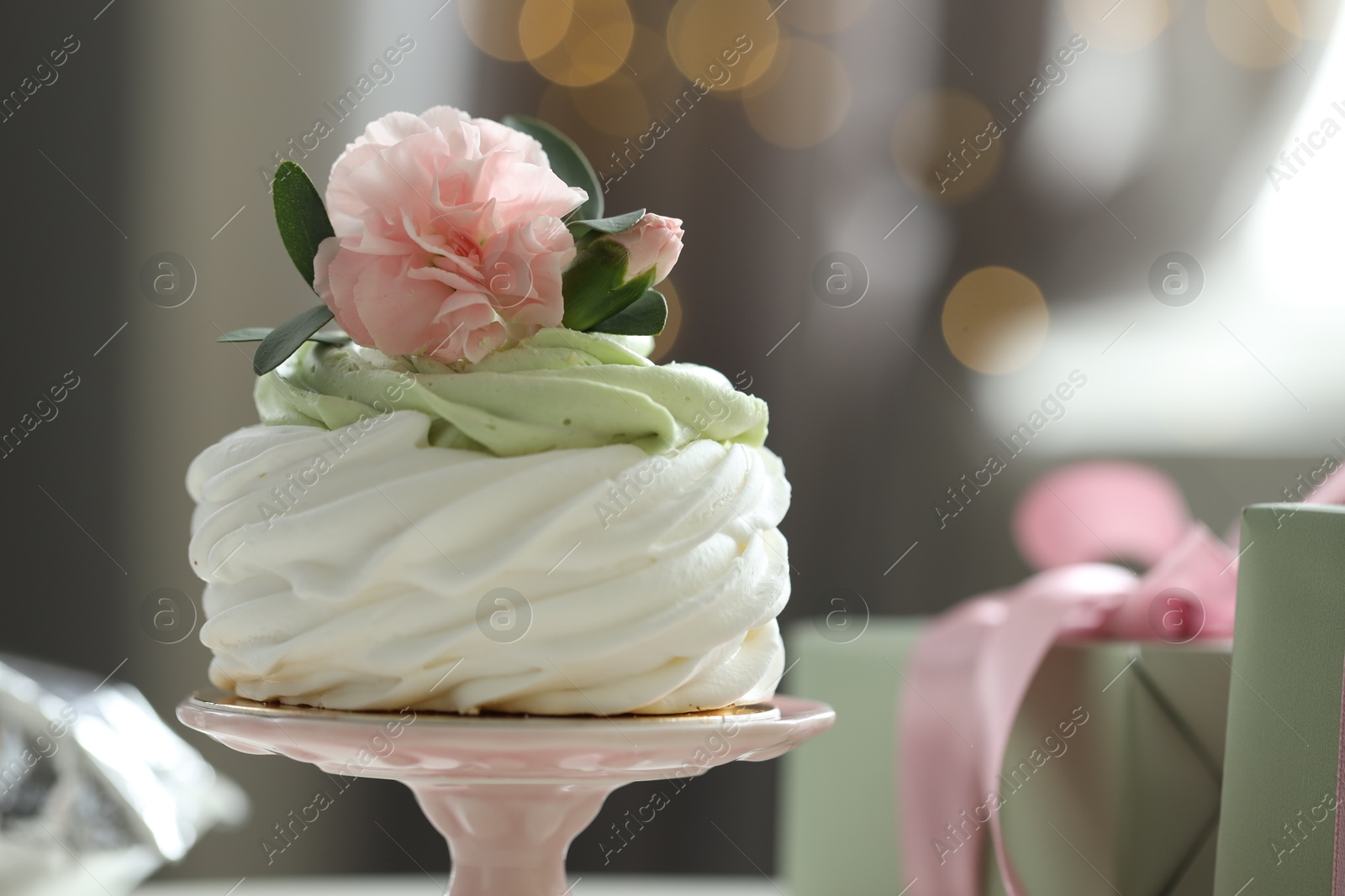 Photo of Tasty cupcake with floral decor on blurred background with lights, space for text. Bokeh effect