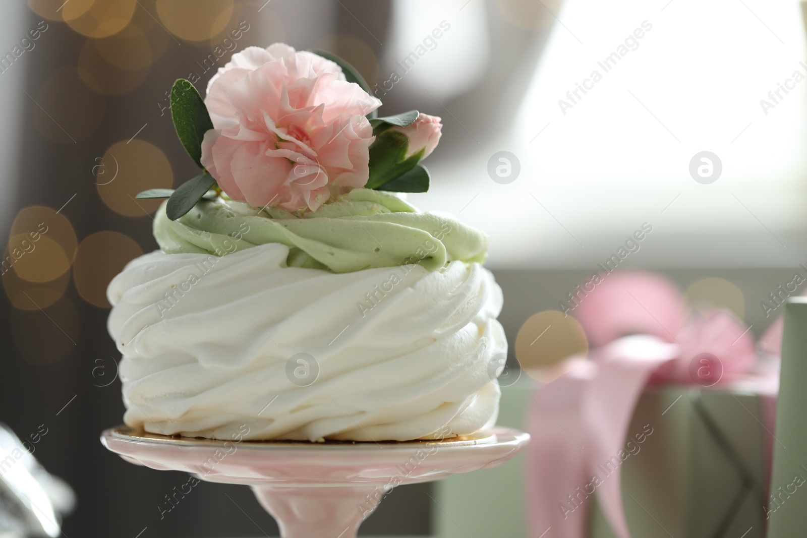 Photo of Tasty cupcake with floral decor on blurred background with lights, space for text. Bokeh effect