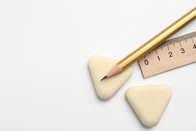 Photo of Erasers, ruler and pencil on white background, flat lay. Space for text