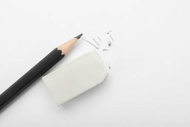 Eraser and pencil on white background, flat lay. Space for text