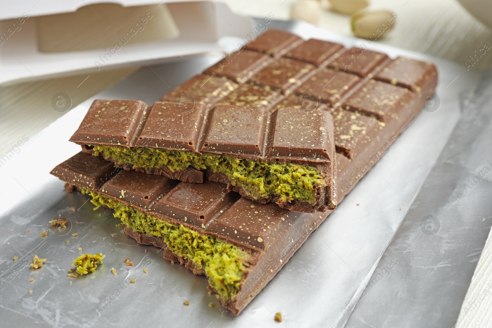 Delicious Dubai chocolate with pistachios and knafeh on table, closeup Photo of Delicious Dubai chocolate with pistachios and knafeh on table, closeup