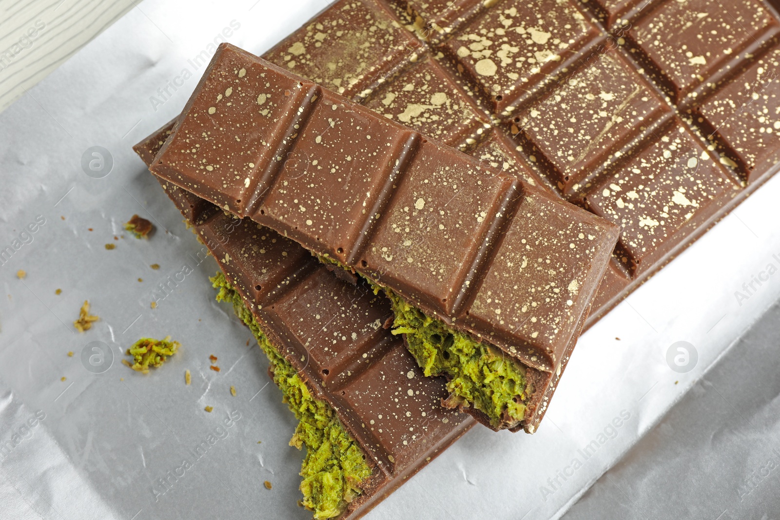Delicious Dubai chocolate with pistachios and knafeh on table, top view Photo of Delicious Dubai chocolate with pistachios and knafeh on table, top view