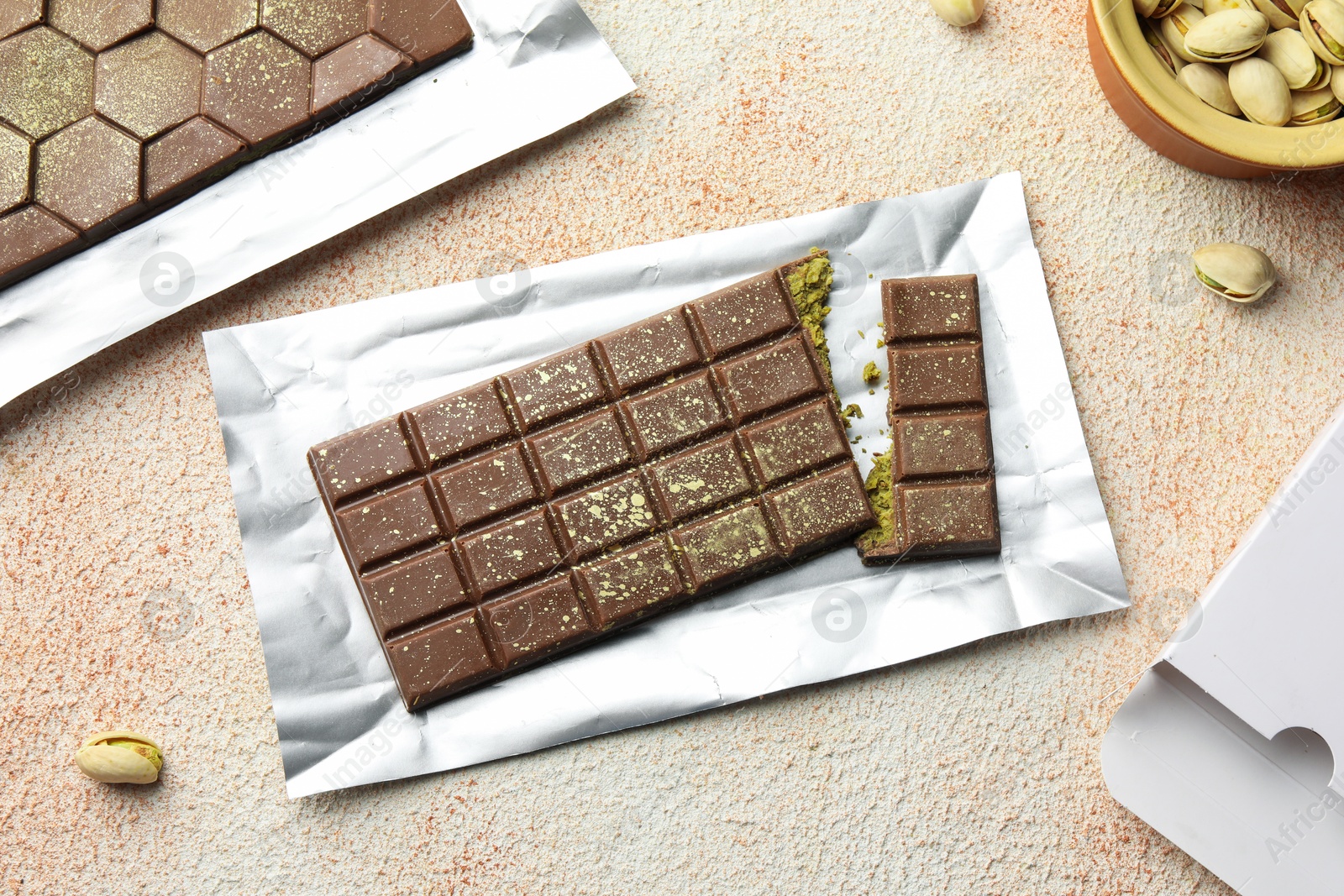 Delicious Dubai chocolate with pistachios and knafeh on color textured table, flat lay Photo of Delicious Dubai chocolate with pistachios and knafeh on color textured table, flat lay